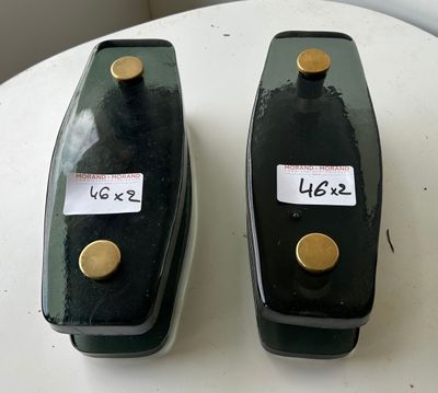 two black vases on a white table with labels on them