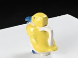 a yellow duck figurine sitting on top of a white table