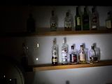 de nombreuses bouteilles d'alcool posées sur une étagère dans l'obscurité