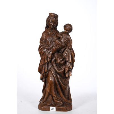 une statue en bois représentant une femme tenant un enfant