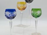 plusieurs verres à vin de différentes couleurs posés sur une table blanche