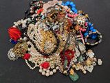 a pile of assorted jewelry on a black surface