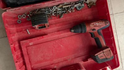 une boîte à outils rouge avec des outils sur le sol