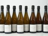six bouteilles de vin sont alignées sur une table