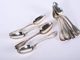 five spoons and two spoons sitting on a white surface
