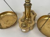 three antique brass scales with chains on them on a white surface