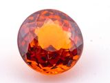 a close up of an orange diamond on a white surface