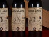 three bottles of wine sitting on top of a table next to a wooden box