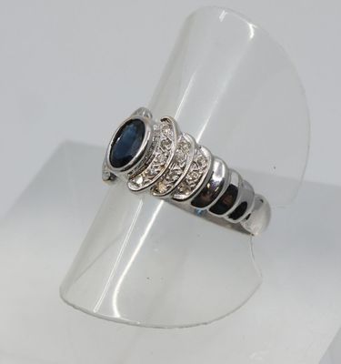 un gros plan d'une bague en argent sertie d'une pierre bleue