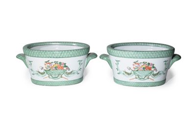 two green and white vases with flowers on them on a white surface