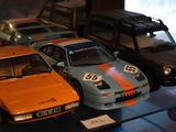 Plusieurs petites voitures sont exposées dans une vitrine.