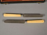 two knives and a knife sharpe sitting on top of a table