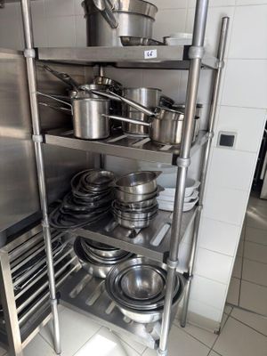 many pots and pans on the shelves in the kitchen
