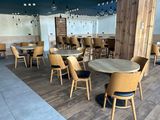 des tables et des chaises dans un restaurant au sol en parquet et aux murs bleus