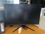 a computer monitor sitting on top of a desk next to a phone