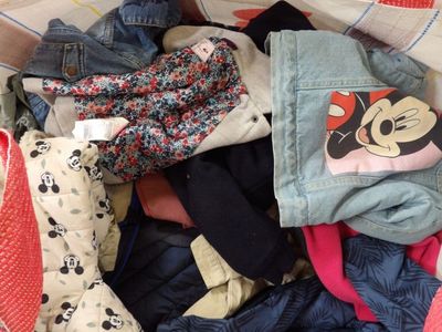 a pile of clothes that is sitting on a bed