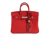 a red leather handbag with a tag on it