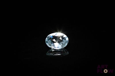 un gros plan d'un diamant topaze bleue sur une surface noire