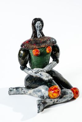 statue représentant une femme assise sur un rocher, un serpent sur les genoux