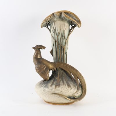 un vase avec un oiseau posé sur une table