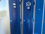 two blue lockers in a room next to a window