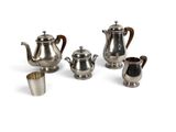 a group of silver teapots and cups on a white surface