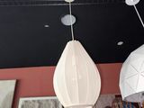 trois lampes blanches suspendues au plafond dans une pièce