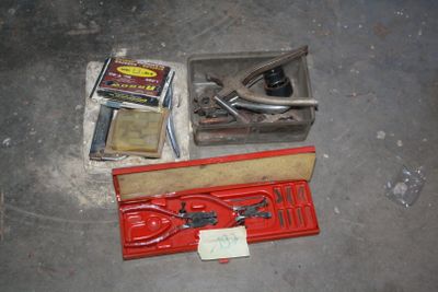 a box of tools sitting on the floor next to a pair of scissors