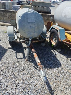 une remorque à laquelle est attelée une citerne, garée sur le bord de la route