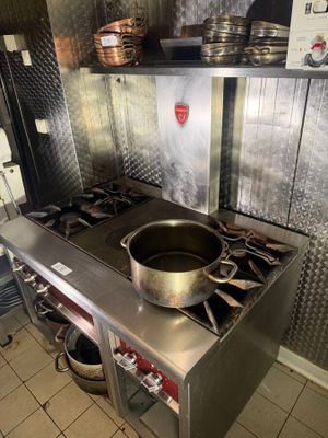 a pot on the stove in the kitchen of a restaurant
