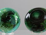 two green and black glass vases on a clear stand