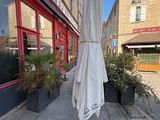 un parapluie blanc fixé à un mât devant un immeuble