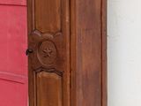 a tall wooden grandfather clock on the corner of a building