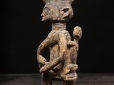 a wooden statue of a man with a bird on his shoulder