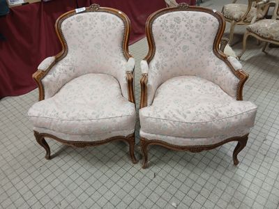 pair of upholstered chairs in a room with a table and chairs