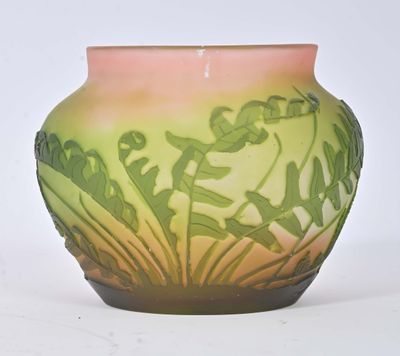 a green and pink vase sitting on a white surface