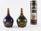 three different types of bottles of liquor are lined up on a white surface