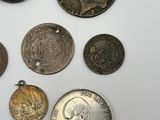 several coins are arranged on a white surface with a white background