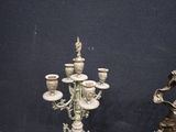 a statue of a woman holding a vase next to a candelabra