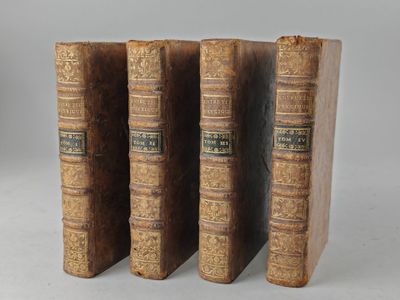 three old books sitting on top of each other on a white surface