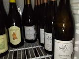 many bottles of wine in the refrigerator on the shelf