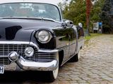 a black vintage car parked on a cobblestone street