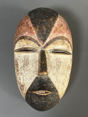 une image représentant un masque en bois sur lequel est peint un visage