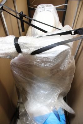 un sac en plastique enroulé autour d'un mannequin dans une pièce