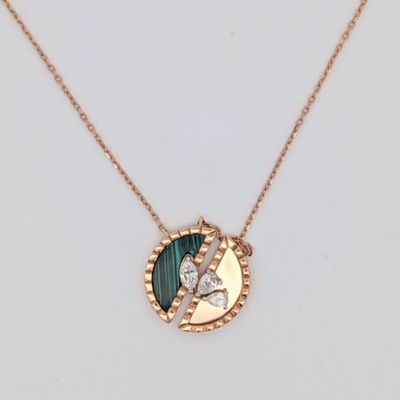 un collier en or orné d'un pendentif vert et blanc