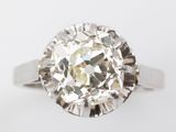 a close up of a diamond ring on a white surface