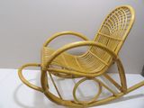a yellow rocking chair that is sitting on a white surface