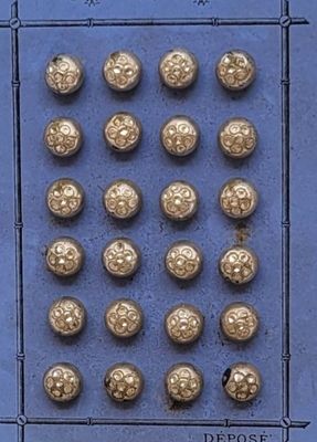 une photo représentant des boutons dorés sur fond bleu
