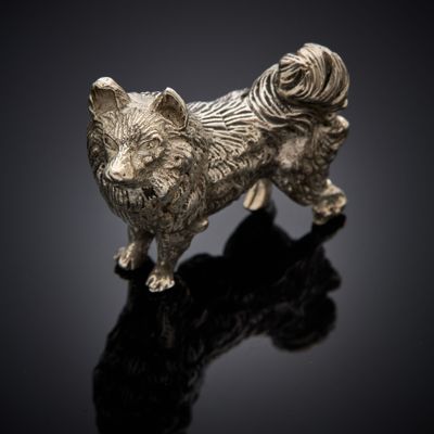 silver statue of a dog on a black surface