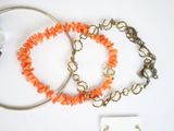 two bracelets with orange coral beads and a silver bracelet